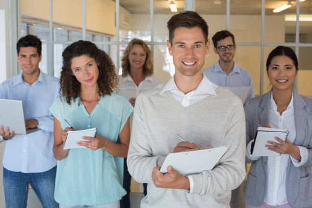 istock Casual boss standing in front of his team all taking notes 842044420