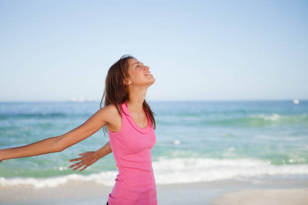 istock Young woman standing with her arms spread on the beach 842089490