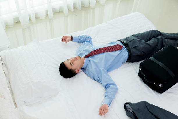 istock Businessman lying on bed with luggage 842090036