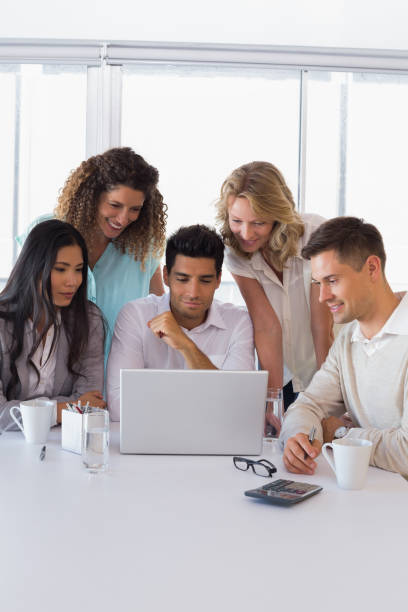 istock Casual smiling business team having a meeting using laptop 842090154