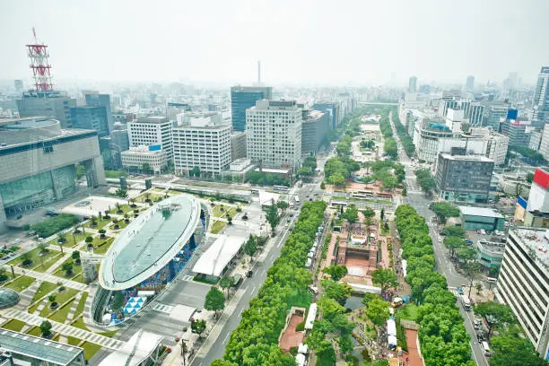 Travel concept - Panoramic modern city bird eye view on Nagoya TV Tower, landmark of Nagoya. Oasis21, Aichi art center and holly tree plaza under modern city with blue and sunny morning sky in Japan