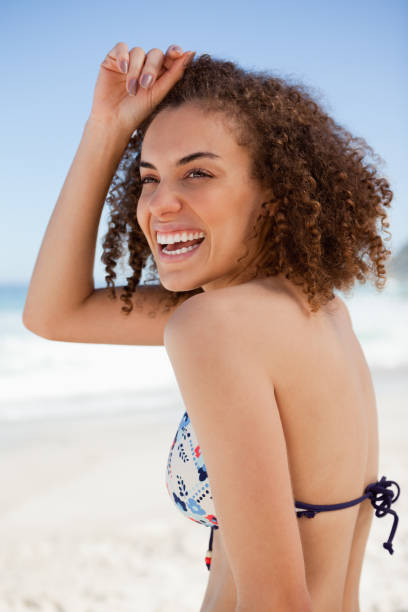 istock Smiling woman placing her hand on her forehead while standing on the beach 842096546