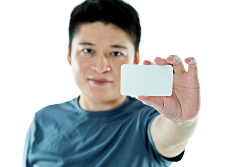 Young man showing a business card against white background.