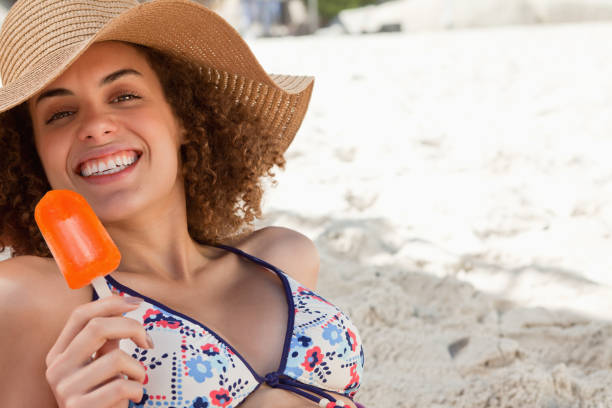 istock Smiling woman showing a beaming smile while holding an ice looly 842103762
