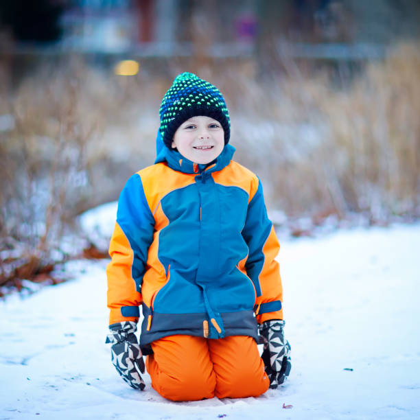 istock Happy kid boy having fun with snow in winter 842107676