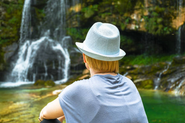 istock Woman sitting by the waterfall 842112008