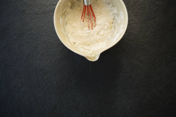 istock Overhead view of batter with wire whisk in bowl 842112192