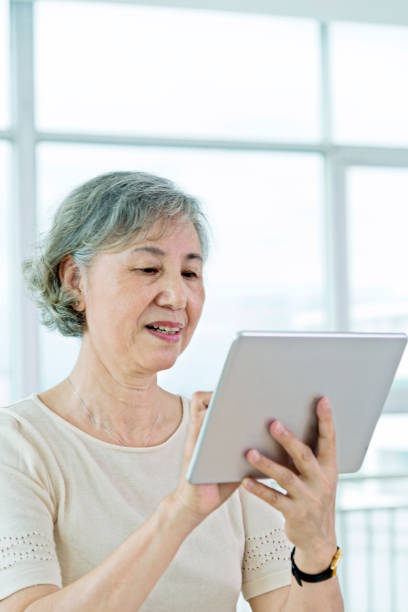istock Asian senior woman using a digital tablet at home 842112202