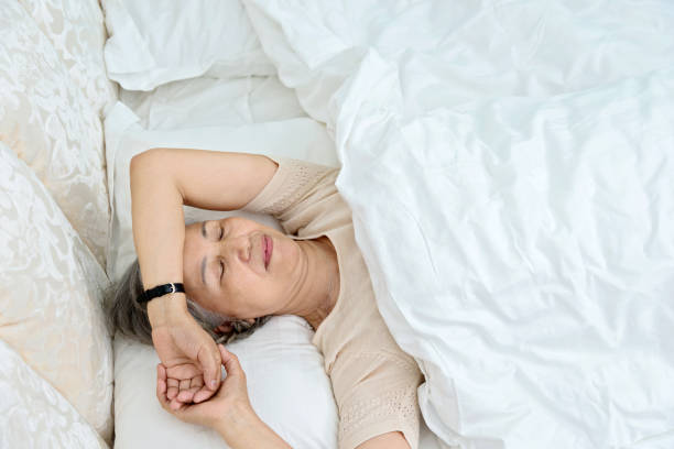 istock Senior woman lying in bed sleeping 842112654