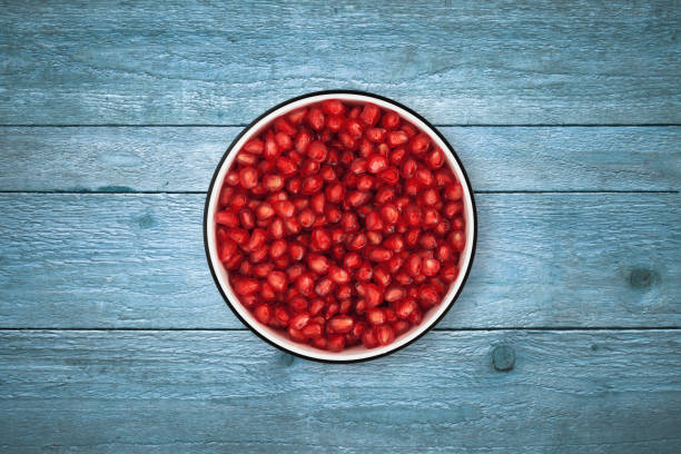 istock Pomegranate seeds bowl on wood background from directly above 842120046