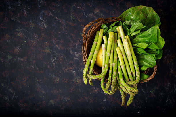 Fresh asparagus in basket on dark  background.