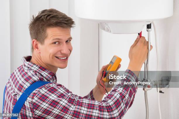 Male Plumber Examining Electric Boiler Stock Photo - Download Image Now - Radiator - Heater, Mechanic, Electric Heater