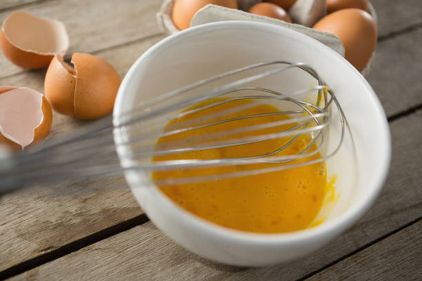 istock Close up of egg in bowl with wire whisk by eggshells 842130542