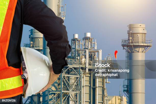 Engineering Man With White Safety Helmet Standing In Front Of Oil Refinery Building Structure In Heavy Petrochemical Industry Stock Photo - Download Image Now