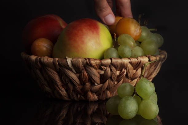 istock Fruits of grapes, plums and an apple in a wicker basket 842140764