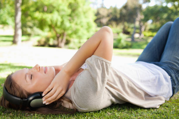 istock Woman lying on the lawn while enjoying music 842144142