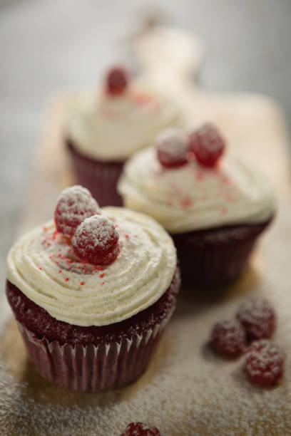 istock Close up of cupcakes with raspberries on cutting board 842144646