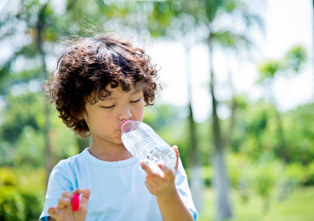 istock Young asian boy drinking water outdoors 842144986