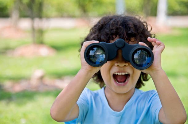 mały chłopiec trzymający lornetkę w parku - little boys discovery binoculars child zdjęcia i obrazy z banku zdjęć