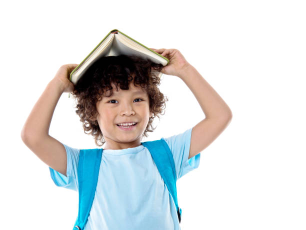 Little asian boy with a book against white background