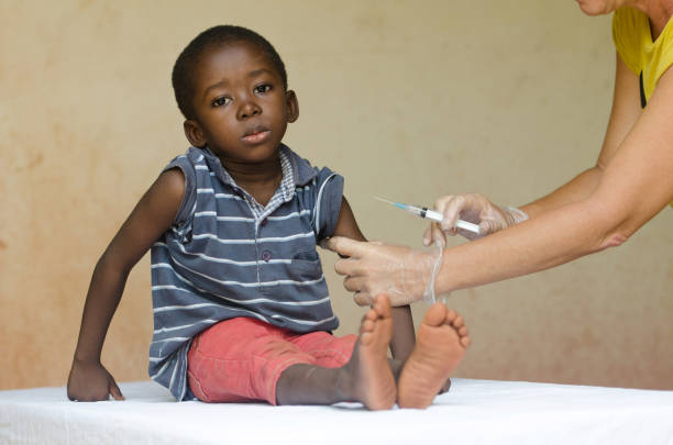 triest afrikaanse jongen klaar te krijgen van een injectie van een vrijwilliger verpleegster in bamako, mali - afrika afrika stockfoto's en -beelden