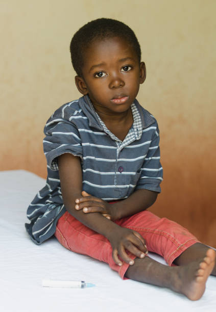 kleine jongen zitten in een ziekenhuis te wachten om een injectie - afrika afrika stockfoto's en -beelden