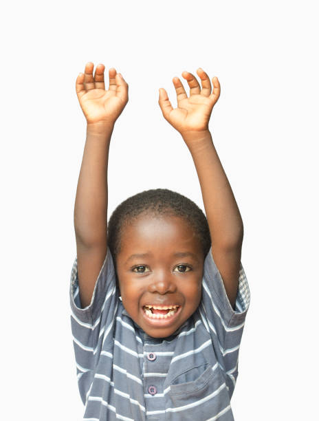 mały afrykański chłopiec trzymający ręce w powietrzu, śmiejąc się i uśmiechając się - male vertical photography studio shot zdjęcia i obrazy z banku zdjęć