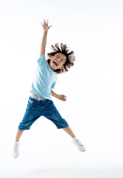 маленький мальчик прыгает изолированы на белом фоне - child celebration cheering victory стоковые фото и изображения