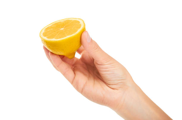 istock female hand holding lemon. Isolated on white background 842152334