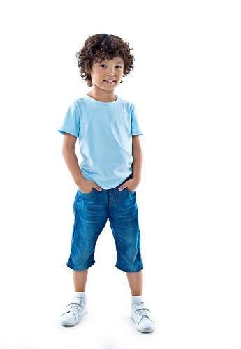 Smiling young boy standing against white background.