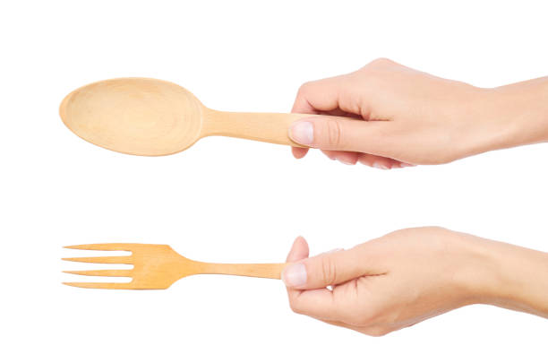 istock wooden fork and spoon in hand isolated on white background 842153382