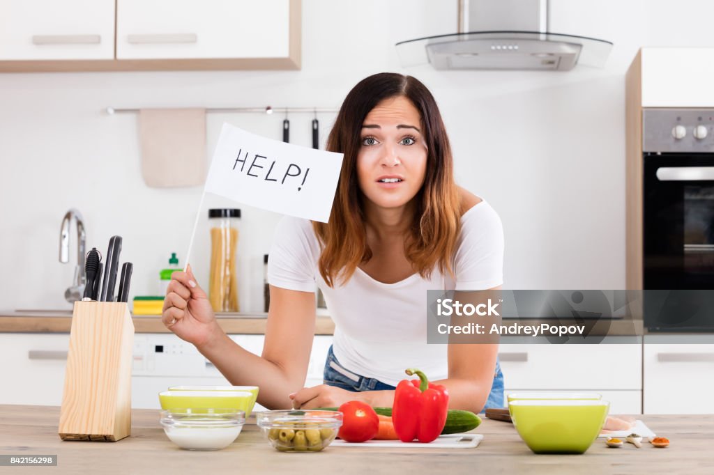 Woman Holding Help Flag In Kitchen Portrait Of Young Woman Holding Help Flag In Kitchen Kitchen Stock Photo