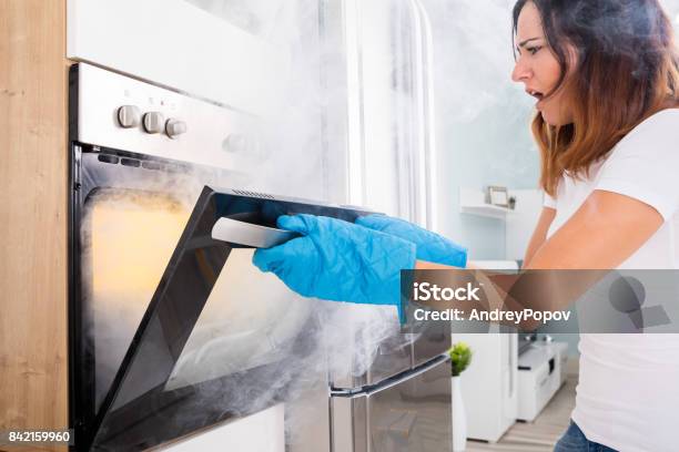 Woman Opening Door Of Oven Full Of Smoke Stock Photo - Download Image Now - Food, Oven, Kitchen