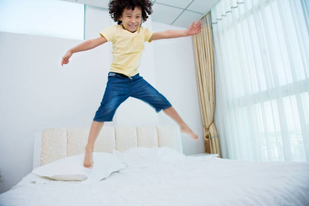 istock Little boy jumping on the bed 842162670
