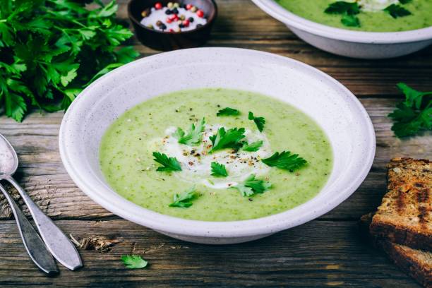 plato de sopa de crema de calabacín verde con perejil fresco - eating utensil green pea vegetarian food organic fotografías e imágenes de stock