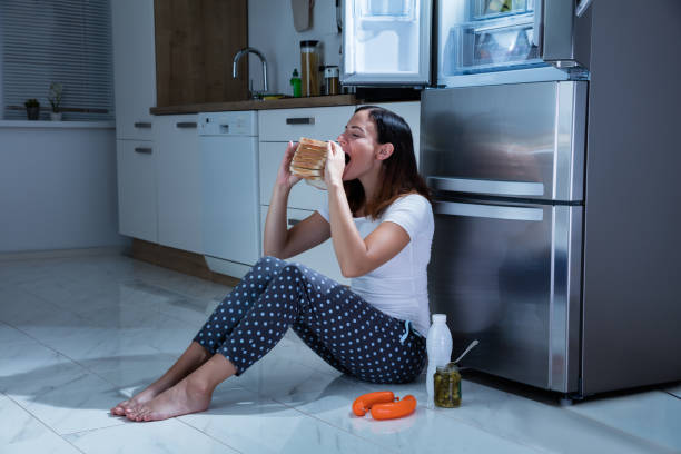 istock Woman Eating Sandwich In Kitchen 842164076