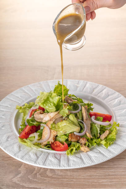 istock cook pours sauce on salad 842174004