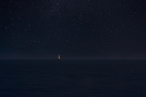 Boat at sea and thousands stars in black sky