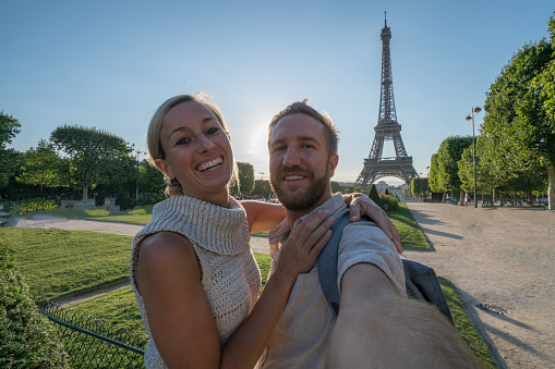 Selfie portrait of young couple in Paris at the Eiffel Tower.