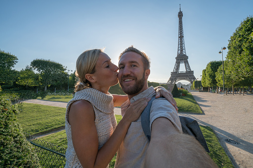 Selfie portrait of young couple in Paris at the Eiffel Tower.