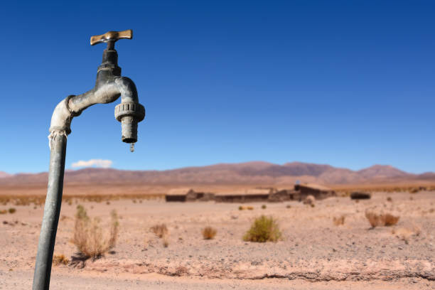 Drips faucet and dry environment in the background Drips faucet and dry environment in the background drought stock pictures, royalty-free photos & images