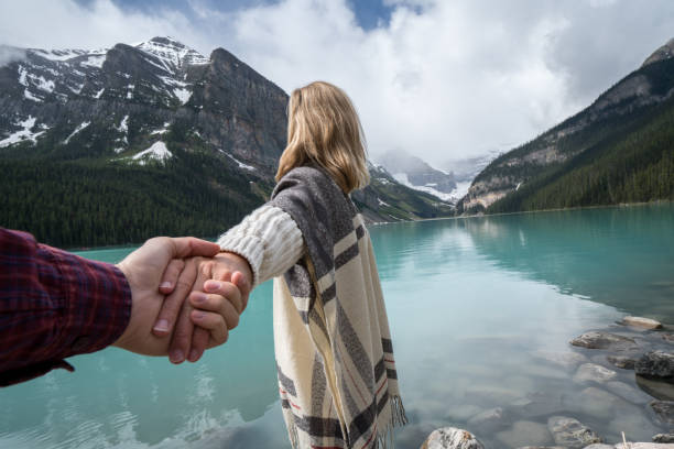 istock Couple holding hands at mountain lake 842180956