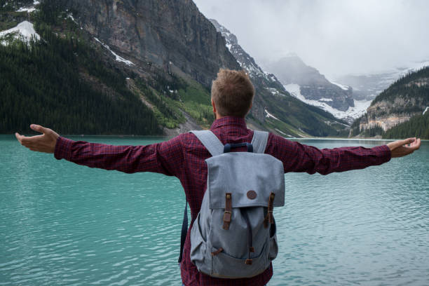 istock Young man arms outstretched at Lake Louise 842181120