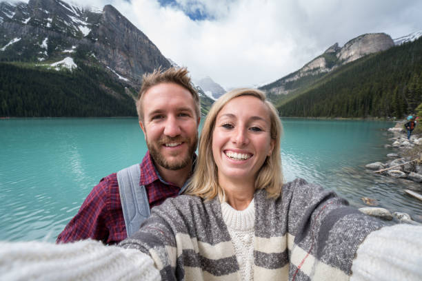 istock Couple taking selfie at mountain lake 842183462