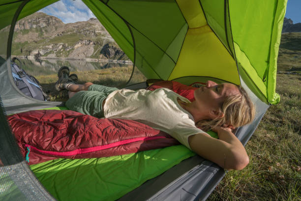 istock Young woman relaxing in tent at sunset 842184026