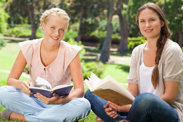 istock Students sitting in the park with their books 842185342