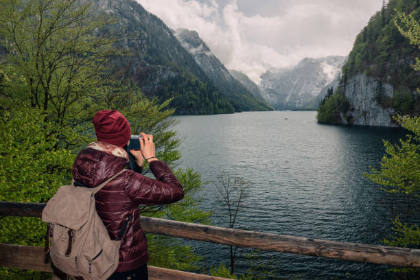 istock Germany. Berchtesgaden National Park. A girl with a camera on a viewing platform with a view of the lake Konigssee 842191128