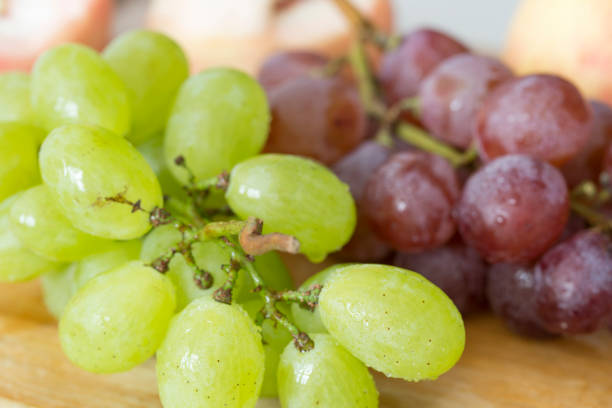 istock Fresh grapes, apple and peaches on a wooden table. 842196782