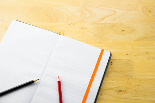 istock top view notebook paper and color pencils on wooden table. 842196854