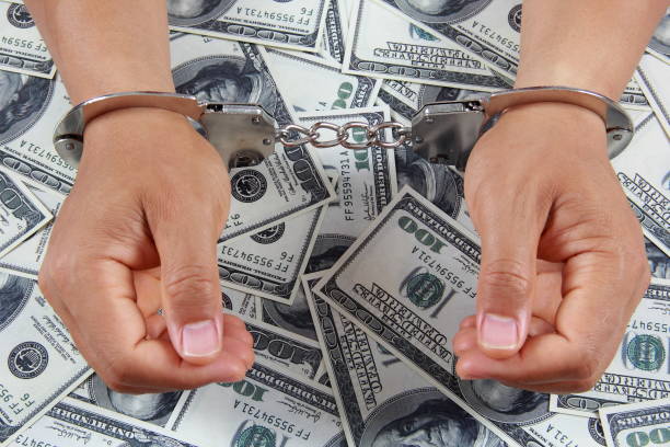 istock Male hands in handcuffs with money 842203046